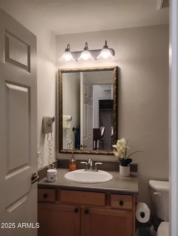 a bathroom with a granite countertop sink and a mirror