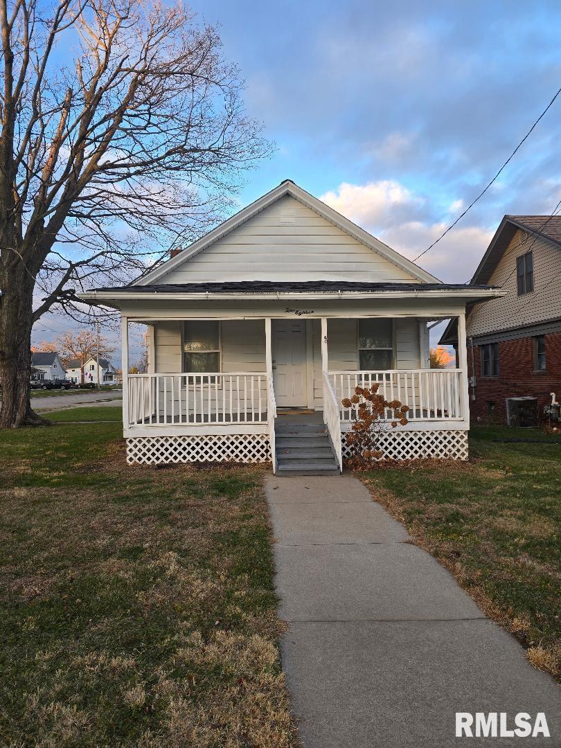 a view of a house with a small yard and wooden fence