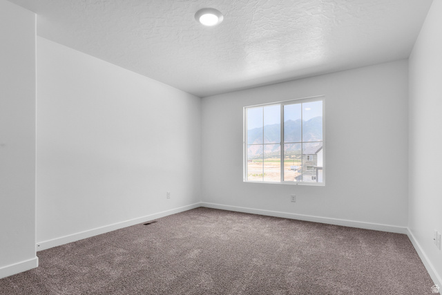 1355 West 2350 South, Unit 11 Perry, UT 84302 - Photo 19 of 39 Bright room with a large multi-pane window, neutral-toned carpet, white painted walls, and white baseboards