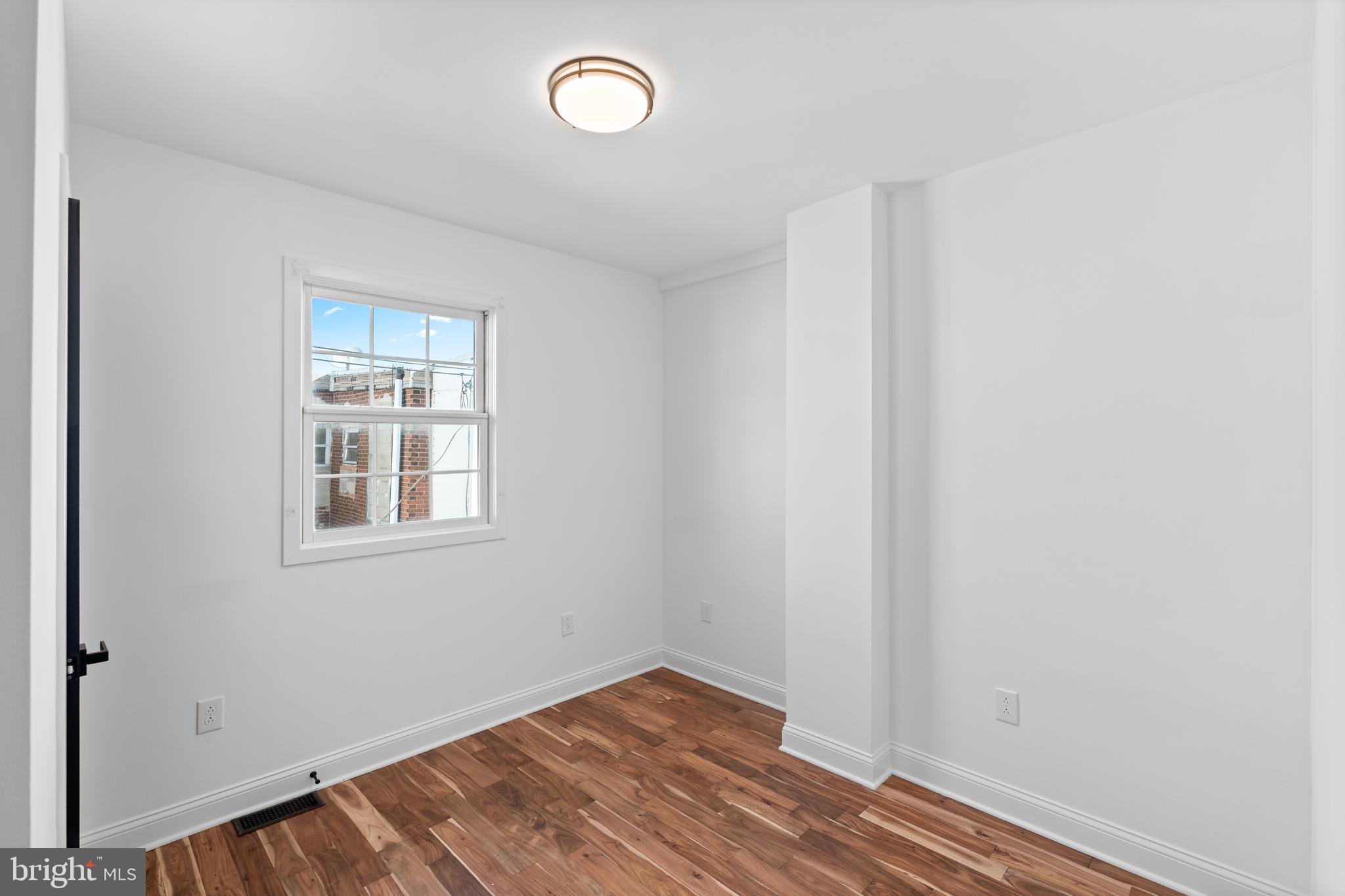 345 Roseberry Street Philadelphia, PA 19148 - Photo 19 of 30 an empty room with wooden floor and windows