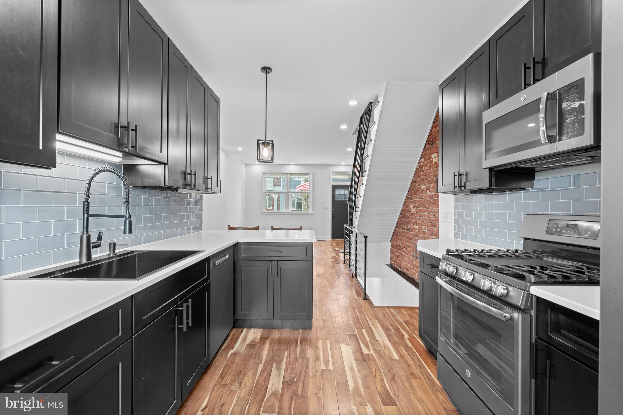 345 Roseberry Street Philadelphia, PA 19148 - Photo 4 of 30 a kitchen with stainless steel appliances granite countertop a sink a stove and a wooden floors