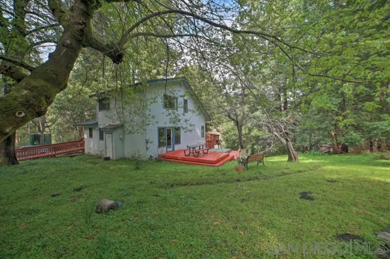 a view of a house with a yard and a tree
