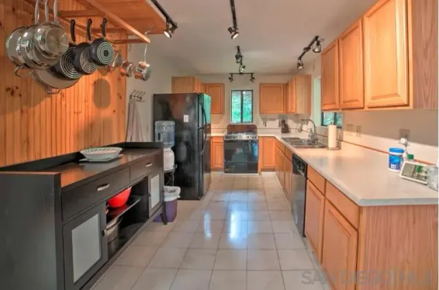 a kitchen with stainless steel appliances granite countertop a sink a counter space and cabinets