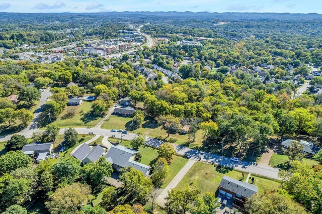an aerial view of residential house with outdoor space and trees all around