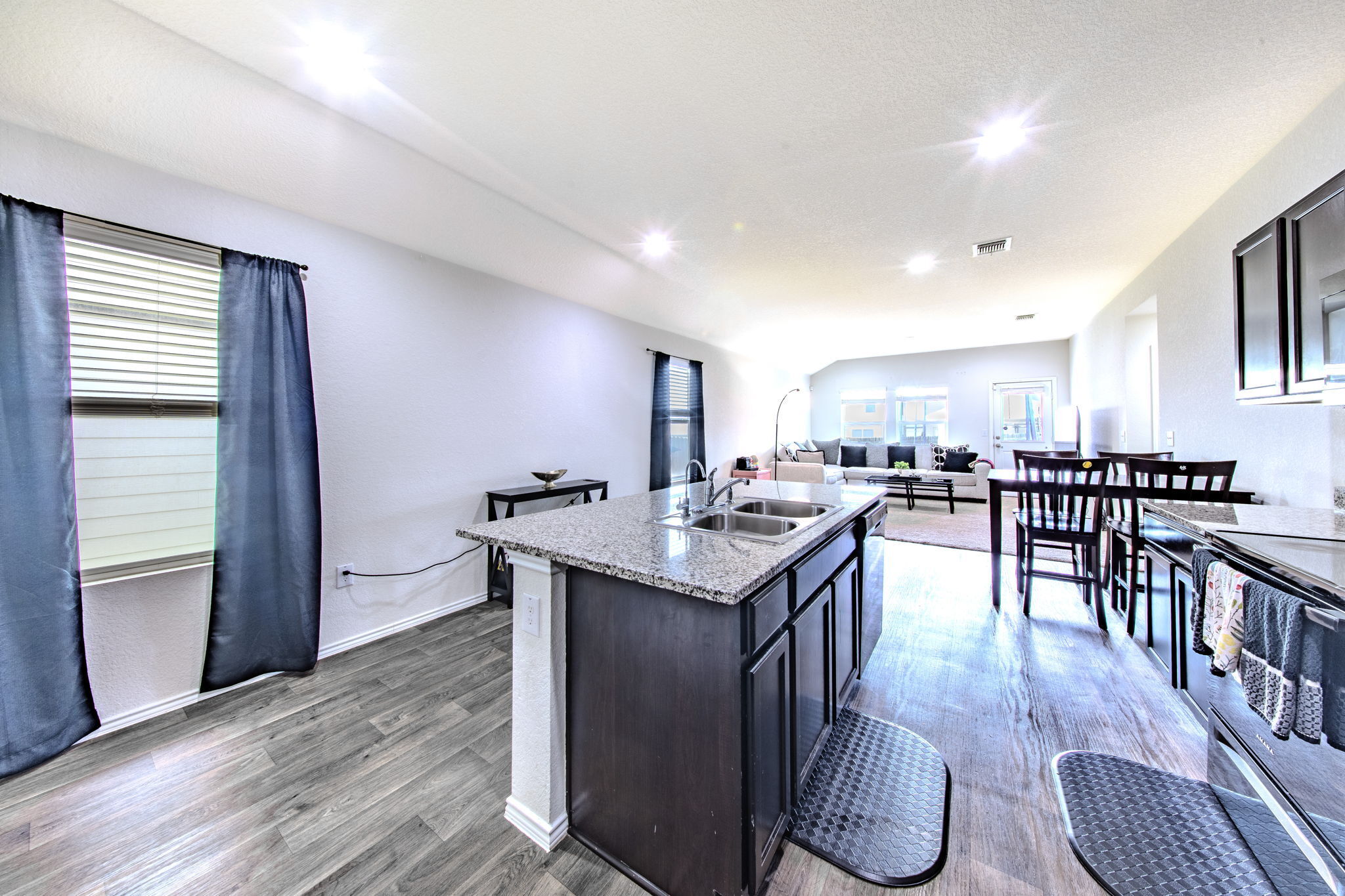 14903 Tuff Road Manor, TX 78653 - Photo 25 of 25 An open concept floorplan seamlessly connects the kitchen with granite counters and a dual sink island to the bright living area.