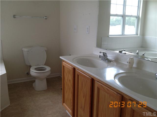 4902 Midstone Lane Raleigh, NC 27610 - Photo 4 of 7 a bathroom with a granite countertop sink and a toilet