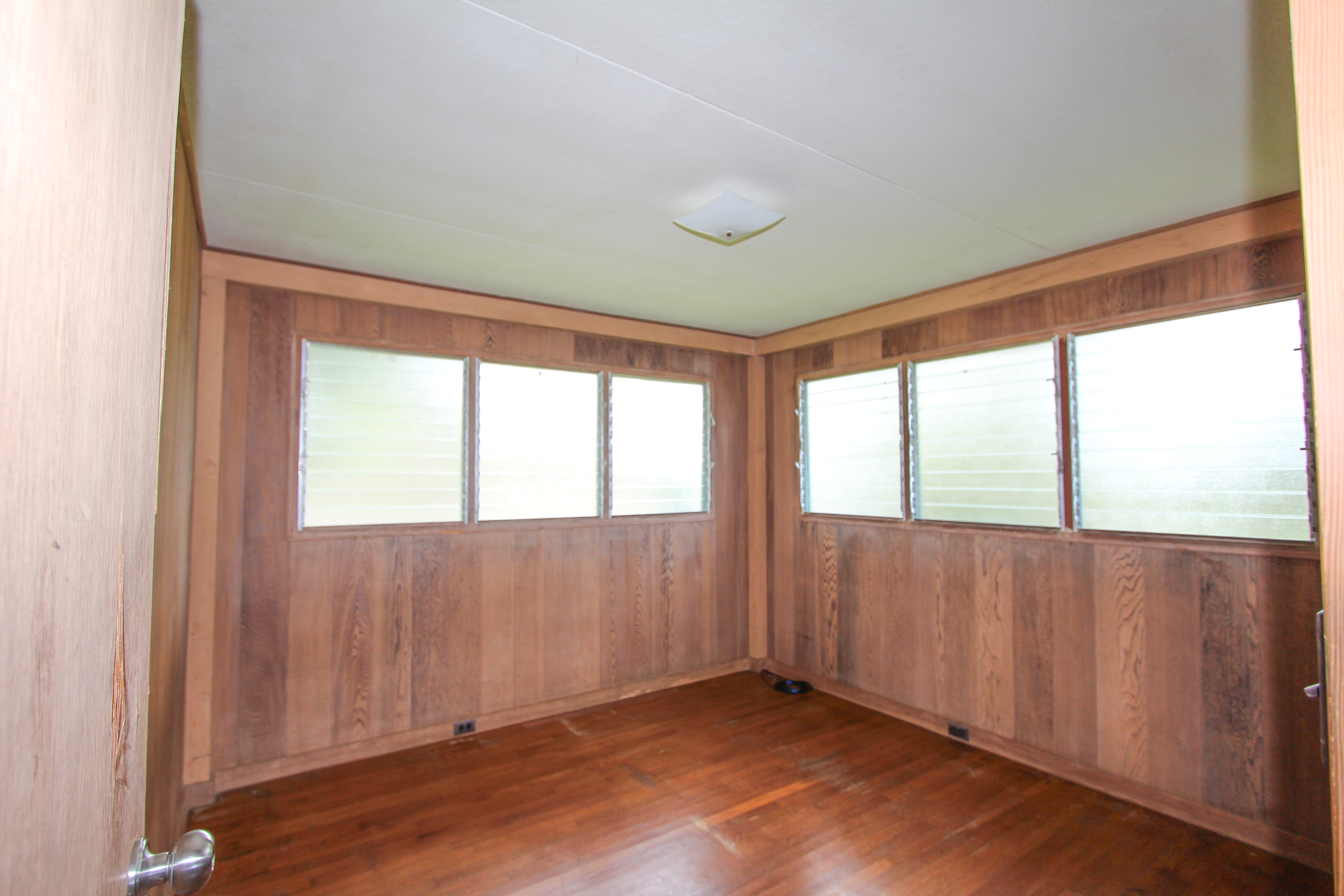 82-1025 Kinue Road Captain Cook, HI 96704 - Photo 9 of 12 an empty room with wooden floor and windows