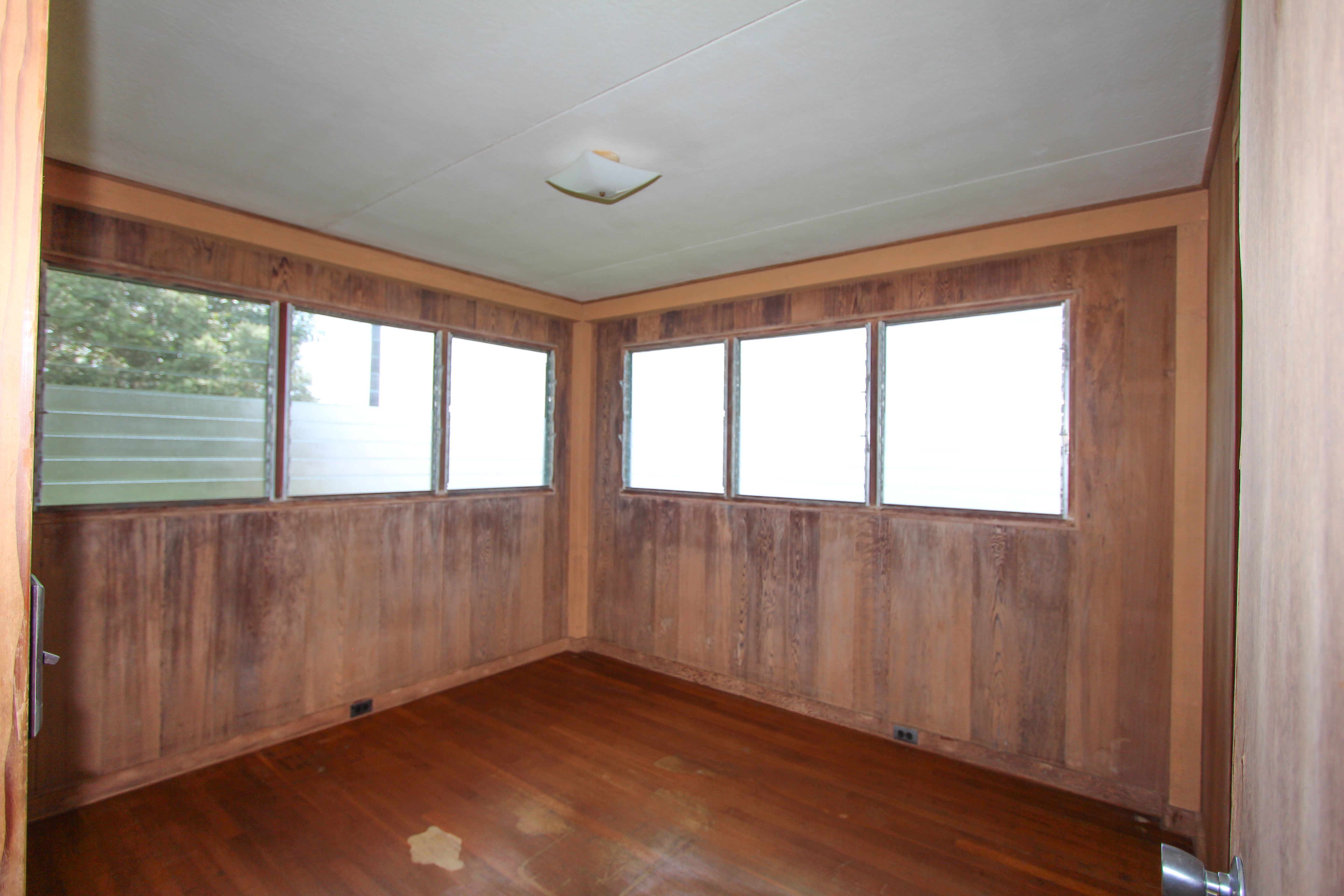 82-1025 Kinue Road Captain Cook, HI 96704 - Photo 10 of 12 a view of an empty room with wooden floor and a window