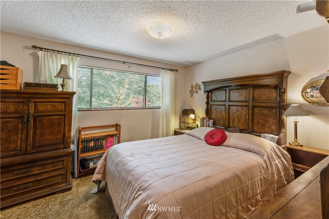 16825 Three Lakes Road Snohomish, WA 98290 - Photo 16 of 32 a bedroom with a bed and wooden floor