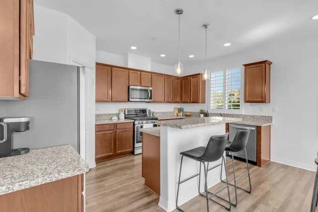 a kitchen with granite countertop cabinets stainless steel appliances and a counter space