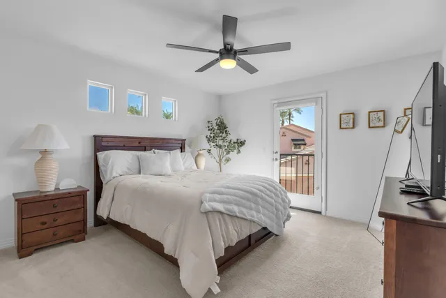 a bedroom with a bed and a flat tv screen on the dresser