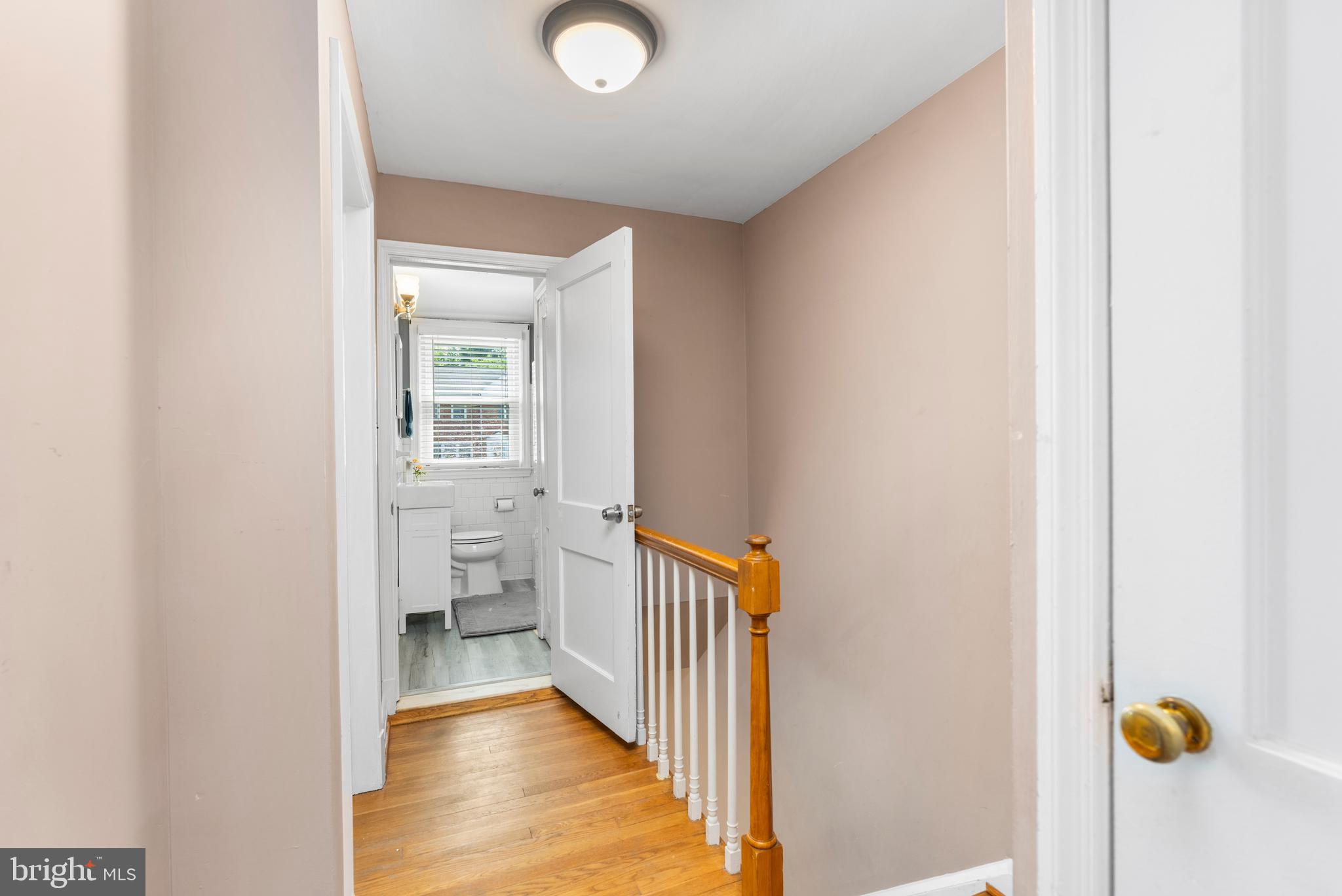 1606 Loch Ness Road Baltimore, MD 21286 - Photo 13 of 36 a view of a hallway with wooden floor and a bathroom