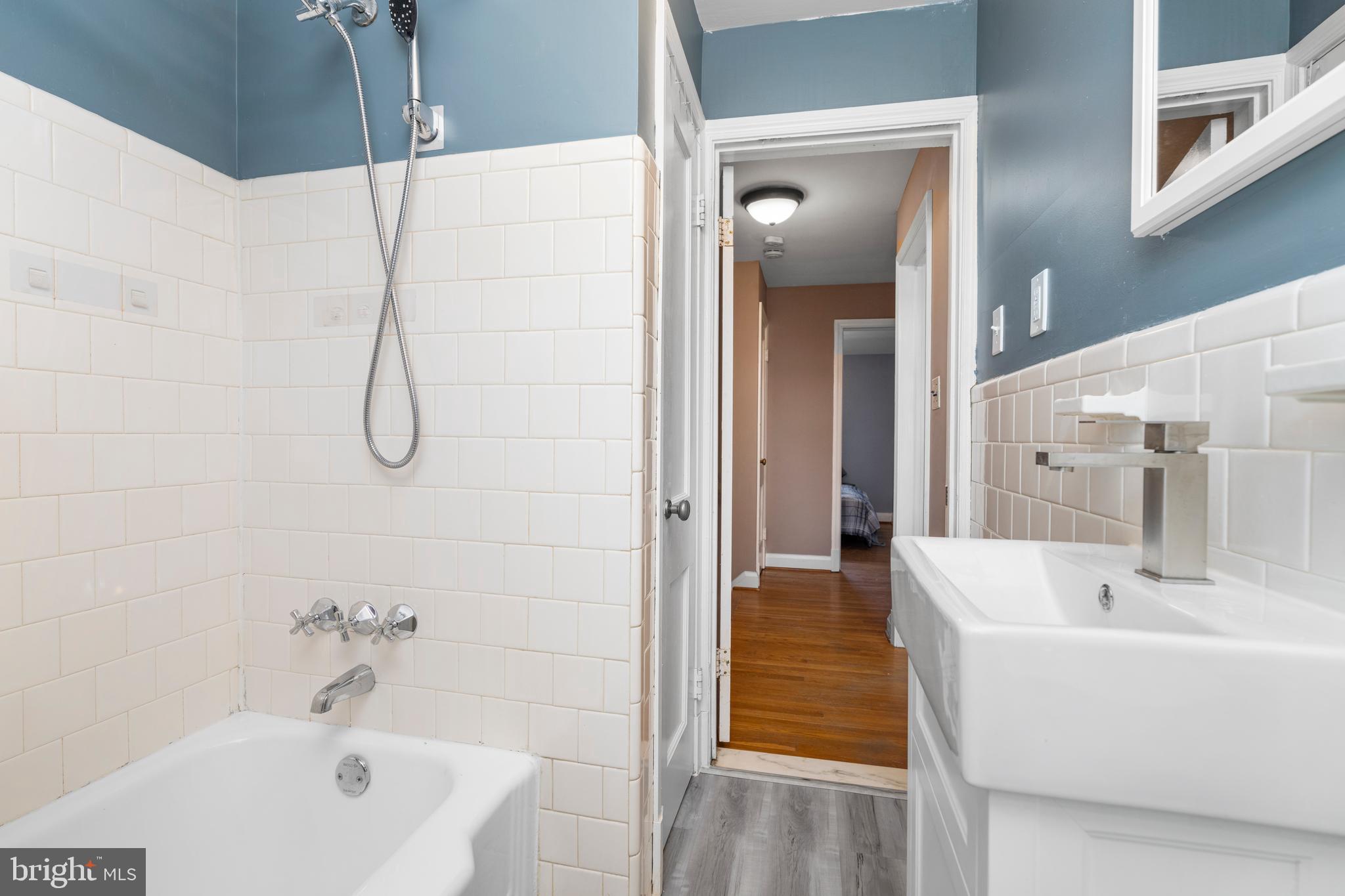 1606 Loch Ness Road Baltimore, MD 21286 - Photo 15 of 36 a bathroom with a white bath tub sitting next to a white sink and vanity