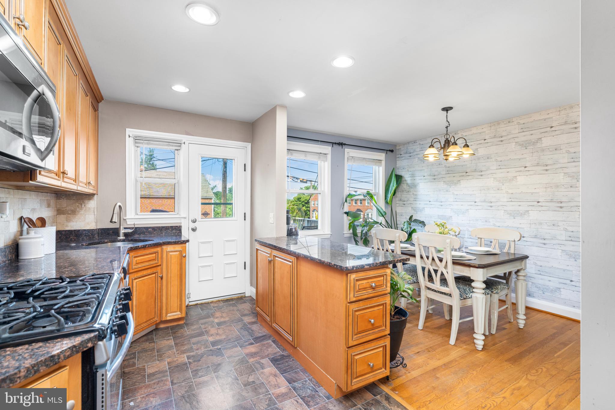 1606 Loch Ness Road Baltimore, MD 21286 - Photo 10 of 36 a kitchen with stainless steel appliances granite countertop a stove top oven a dining table and chairs with wooden floor