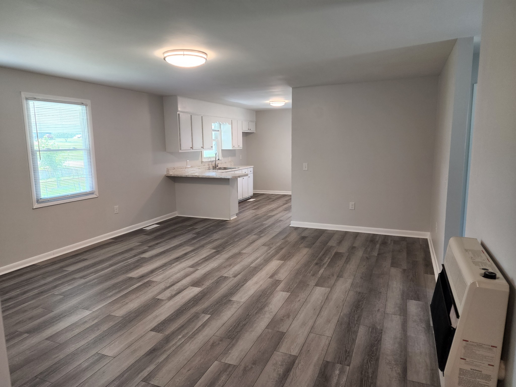 514 West Point Road Lawrenceburg, TN 38464 - Photo 8 of 25 a view of kitchen and empty room with wooden floor