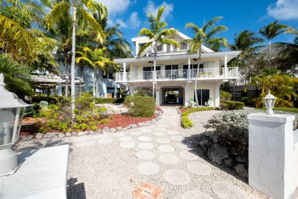 a front view of a house with yard and trees
