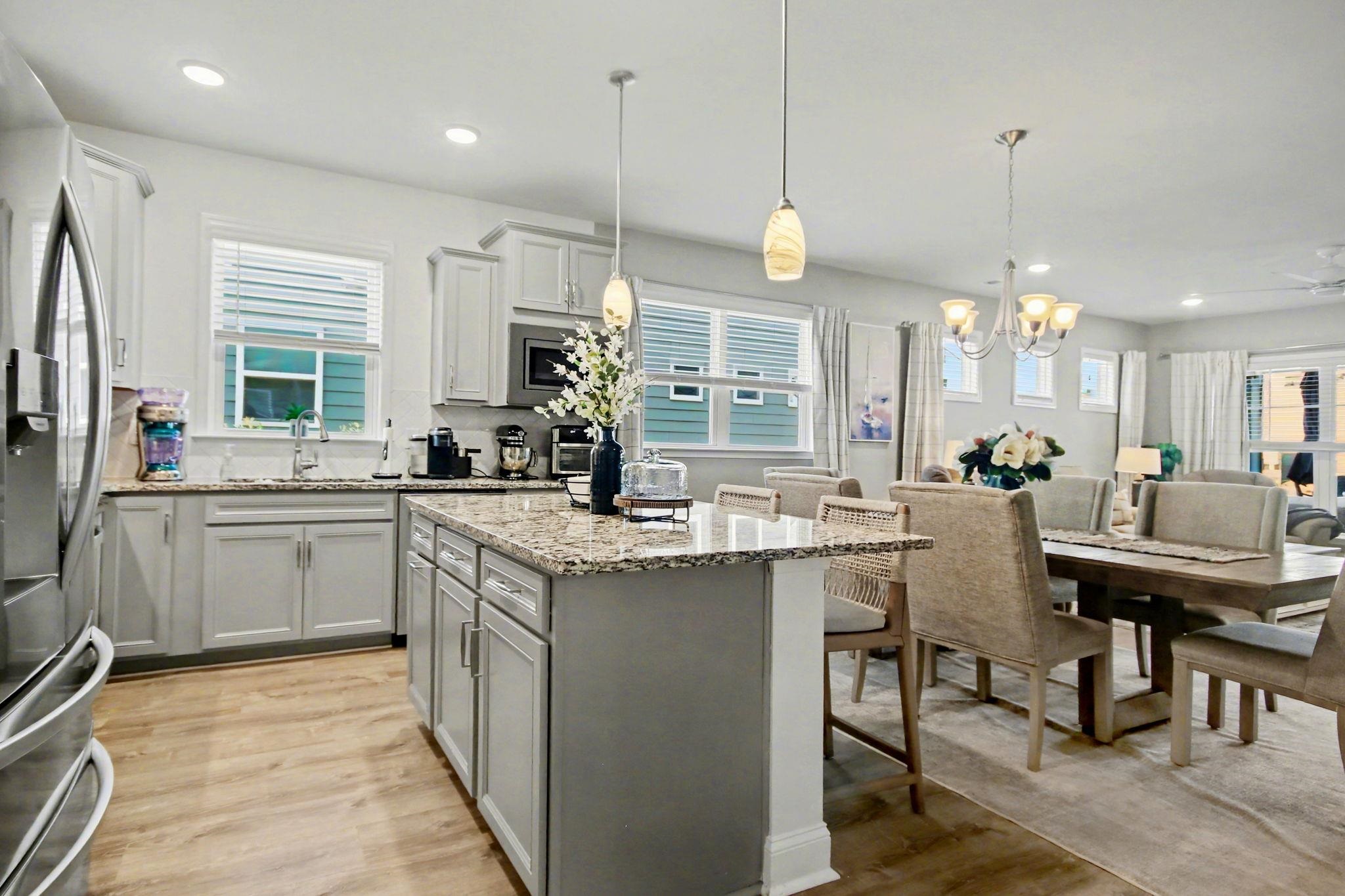 5830 Cremona Drive Myrtle Beach, SC 29577 - Photo 11 of 39 Kitchen featuring stainless steel fridge, light stone countertops, recessed lighting, gray cabinetry, and decorative light fixtures