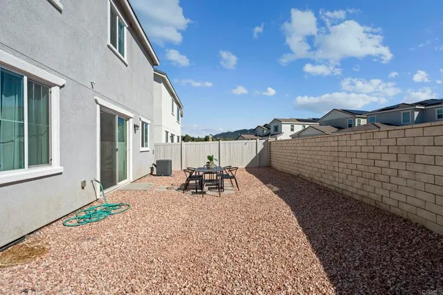 a backyard of a house with table and chairs