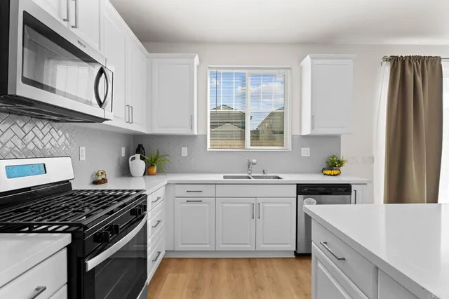 a kitchen with stainless steel appliances a sink stove and cabinets
