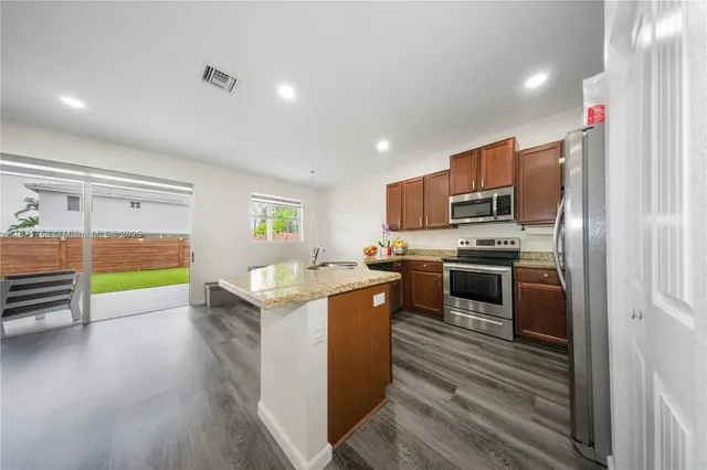 a kitchen with a stove a refrigerator and a microwave