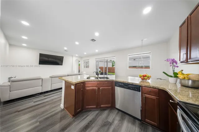 a kitchen with stainless steel appliances granite countertop a sink and cabinets