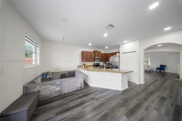 a living room with kitchen island furniture and a wooden floor