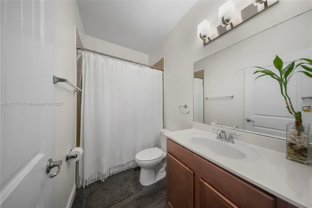 a bathroom with a granite countertop sink a toilet and a mirror