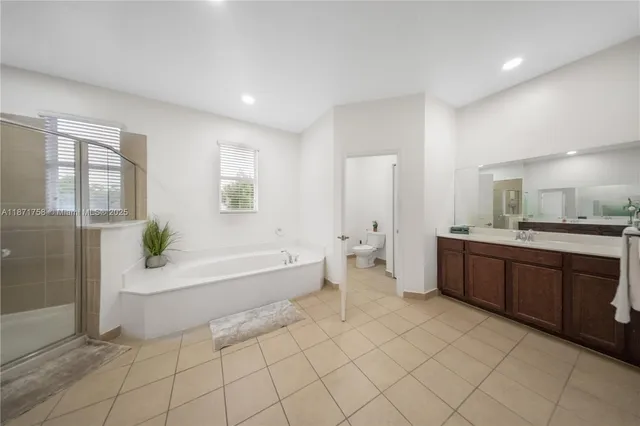 a spacious bathroom with a bathtub sink and mirror