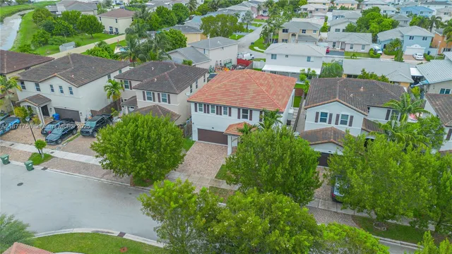 an aerial view of residential houses with outdoor space and street view