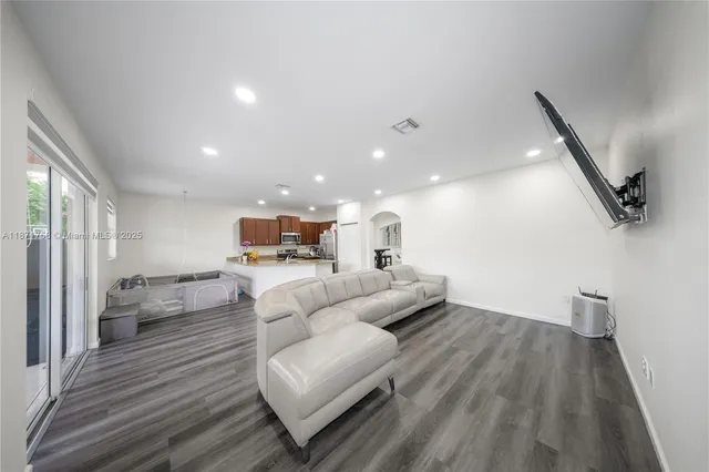 a living room with furniture and a wooden floor