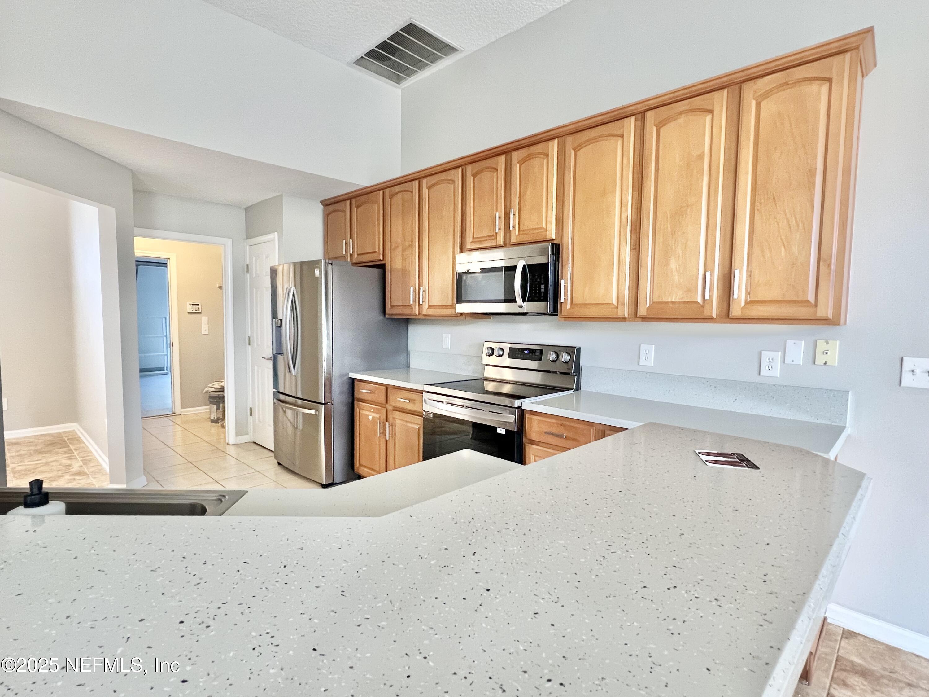 389 Sparrow Branch Circle St. Johns, FL 32259 - Photo 11 of 46 a kitchen with stainless steel appliances a refrigerator sink and microwave