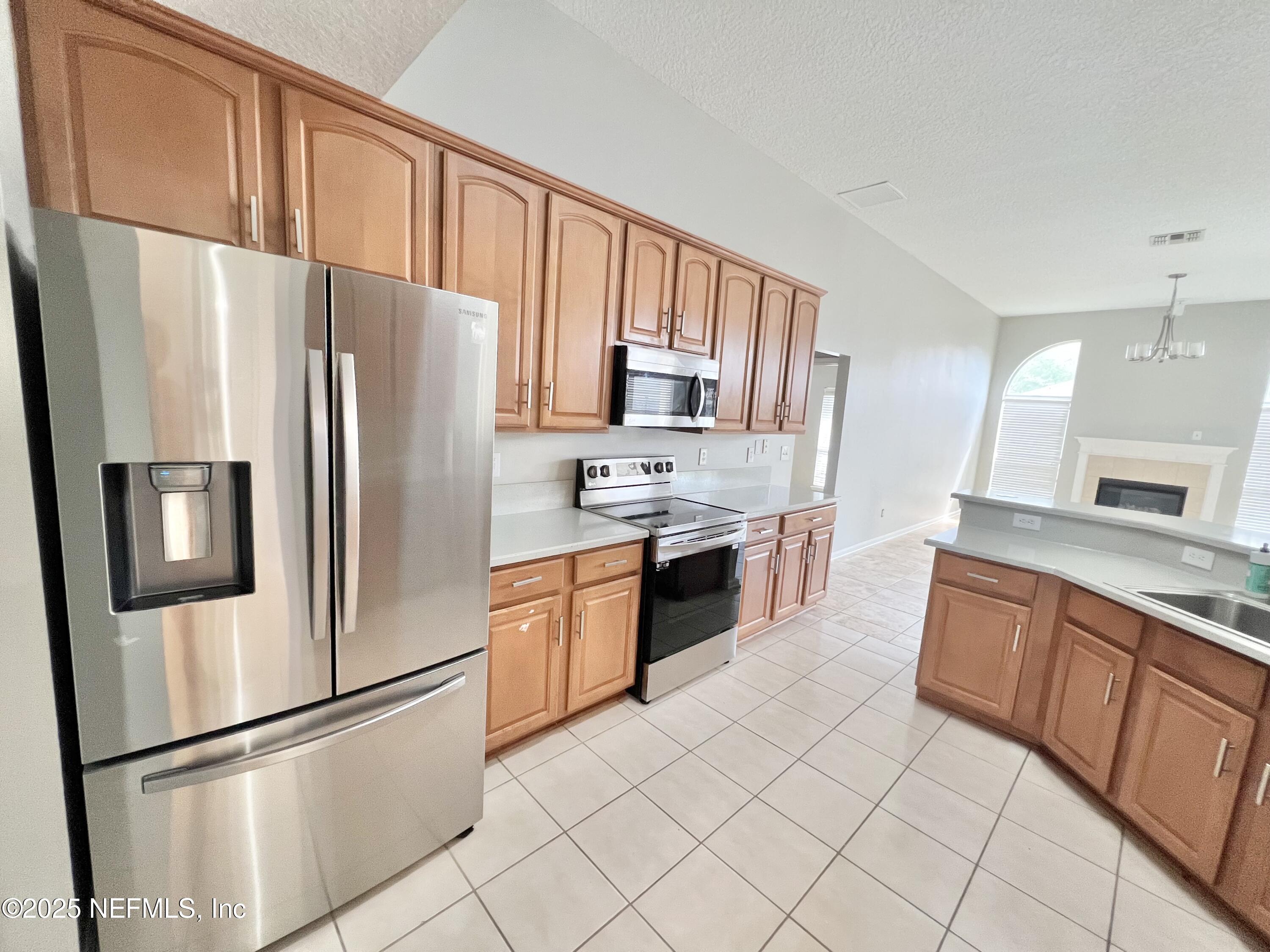 389 Sparrow Branch Circle St. Johns, FL 32259 - Photo 6 of 46 a large kitchen with stainless steel appliances granite countertop a refrigerator stove a sink and a granite counter tops