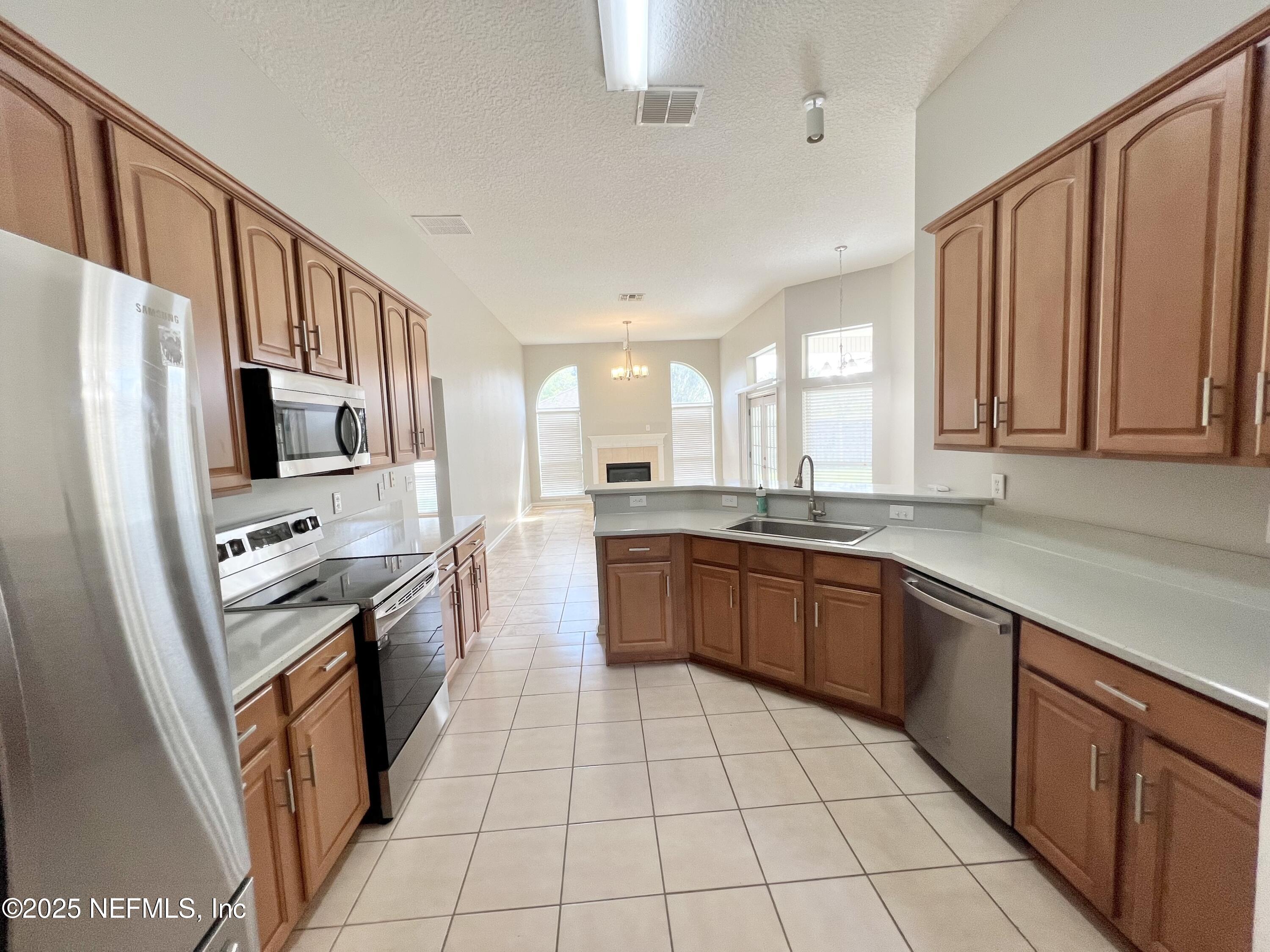 389 Sparrow Branch Circle St. Johns, FL 32259 - Photo 9 of 46 a large kitchen with stainless steel appliances granite countertop a stove top oven a sink dishwasher and a refrigerator