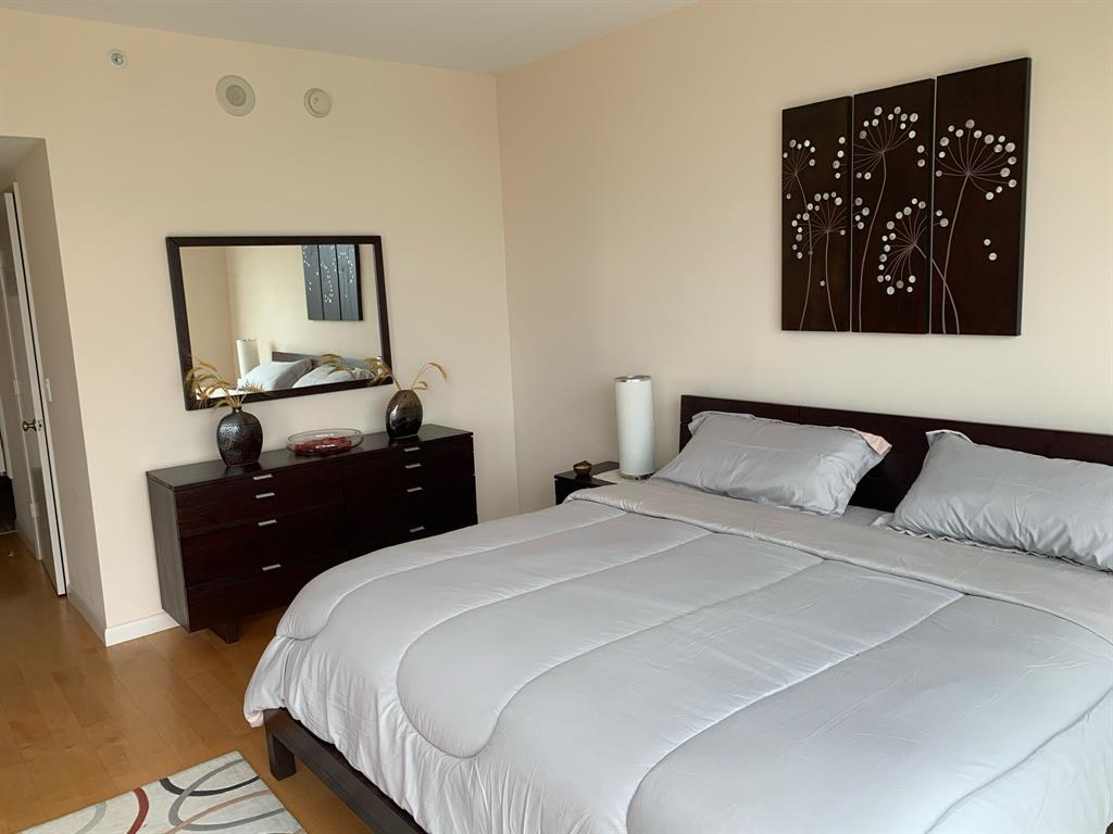 333 Las Olas Way, Unit 2803 Fort Lauderdale, FL 33301 - Photo 17 of 25 a bedroom with a bed and wooden floor