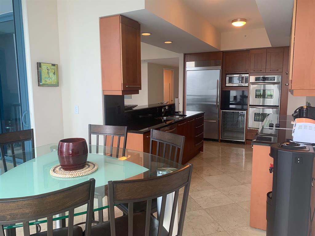 333 Las Olas Way, Unit 2803 Fort Lauderdale, FL 33301 - Photo 20 of 25 a kitchen with a table chairs refrigerator and microwave