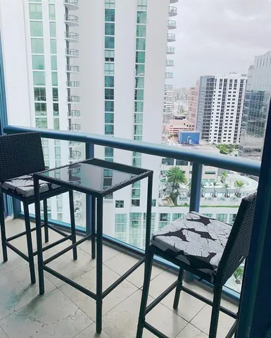 a view of a city from a balcony with furniture