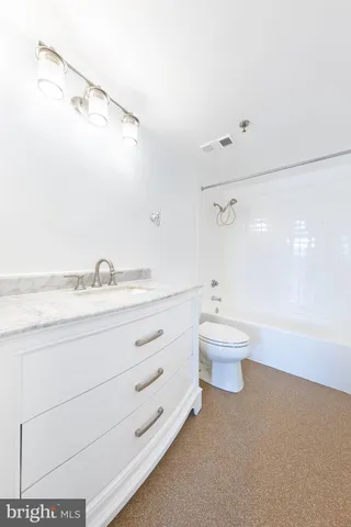 a bathroom with a granite countertop sink toilet a large mirror and shower