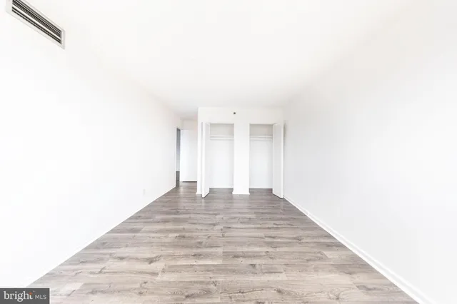 a view of an empty room with wooden floor