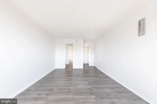 a view of an empty room with wooden floor