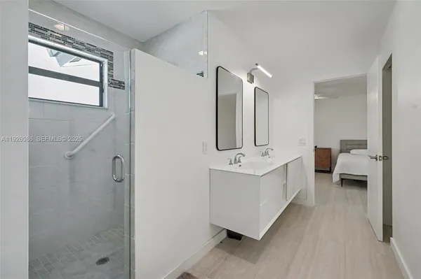 a bedroom with a bed a flat screen tv and a chandelier