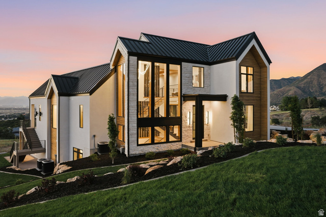 923 North Emery Lane Elk Ridge, UT 84651 - Photo 99 of 101 Modern architectural residence featuring a prominent gabled roofline, expansive floor-to-ceiling windows, and a multi-level exterior staircase