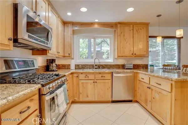 a kitchen with stainless steel appliances granite countertop a stove a sink and a microwave
