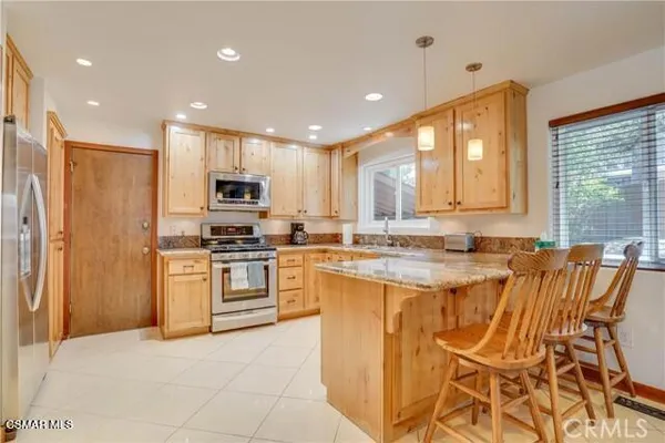 a large kitchen with stainless steel appliances granite countertop a stove a sink and a refrigerator