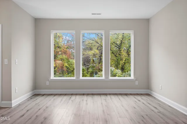 a view of a room with wooden floor chandelier and windows
