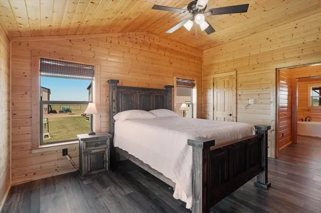 a spacious bedroom with a bed and wooden floor