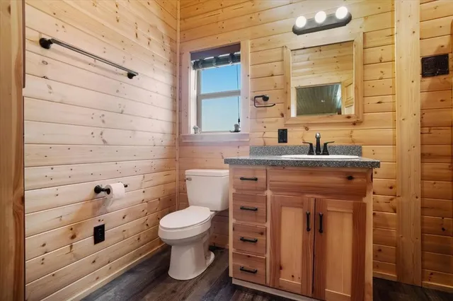 a bathroom with a granite countertop toilet sink and mirror