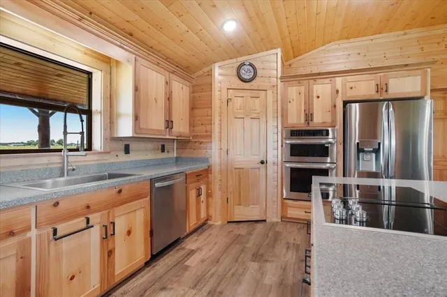 a kitchen with stainless steel appliances granite countertop a refrigerator and a sink