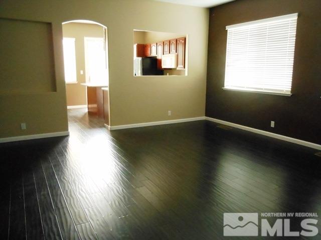 10085 Hampton Park Drive Reno, NV 89521 - Photo 5 of 20 a view of an empty room with wooden floor and a window