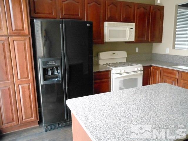 10085 Hampton Park Drive Reno, NV 89521 - Photo 8 of 20 a kitchen with a refrigerator and a sink
