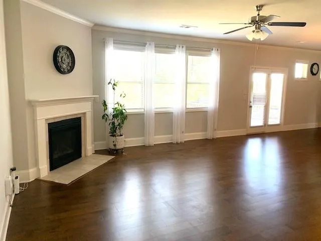 a view of a livingroom with wooden floor and a fireplace